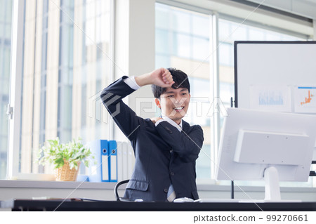 Business desk work young man stretching 99270661