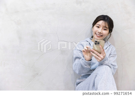 Young woman looking at smartphone in training wear Hip hop dance image 99271654