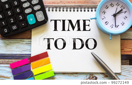 Time to do, the text is written on a notepad and a wooden table. Nearby lies a calculator  99272149