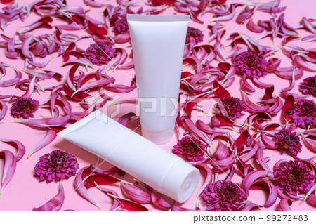 Natural cosmetic products with white bottles and fresh flowers on pink 99272483