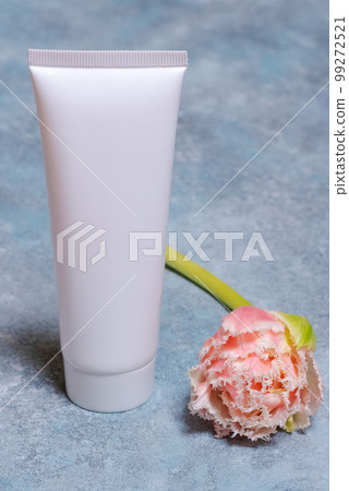 Mockup of an empty packaging white tube with tulips on a blue background mockup Mockup of an empty packaging white tube with tulips on a blue background mockup 99272521