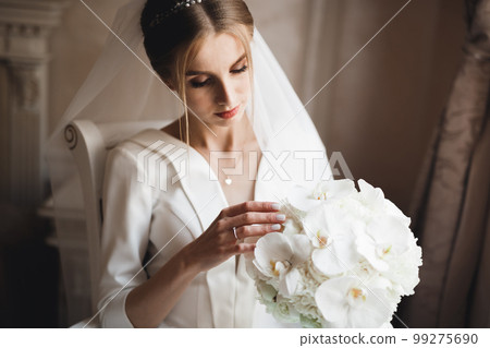 Portrait of stunning bride with long hair posing with great bouquet 99275690
