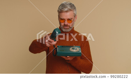 Middle-aged old man talking on wired vintage old-fashioned telephone of 80s advertising call me back 99280222