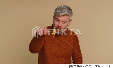 Magician witch senior man gesturing with magic wand making wish come true, casting magician spell Magician witch senior man gesturing with magic wand making wish come true, casting magician spell 99280254