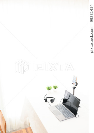 Indoor white table, laptop, smartphone, headphones, foliage plants 99281434