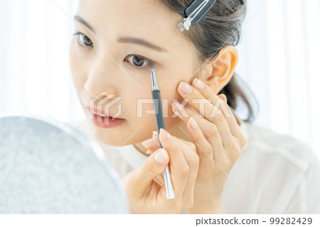 一個年輕女人臉上畫眼線的美容特寫 99282429