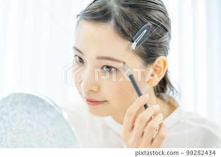 Beauty beauty makeup Close-up of a young woman's face drawing eyebrows Beauty beauty makeup Close-up of a young woman's face drawing eyebrows 99282434
