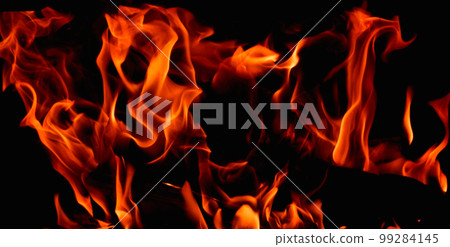 Hot, orange flames of burning wood in the fireplace. Fire dance on black background. Hot, orange flames of burning wood in the fireplace. Fire dance on black background. 99284145