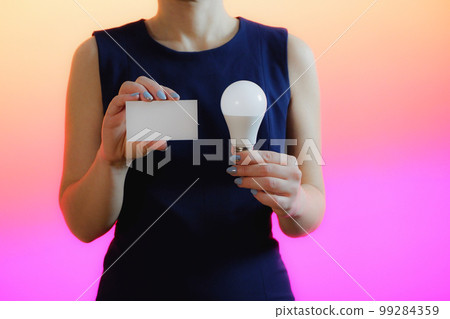A woman holds a light bulb in her hand. Idea, innovation and inspiration concept, background for copy. A woman holds a light bulb in her hand. Idea, innovation and inspiration concept, background for copy. 99284359