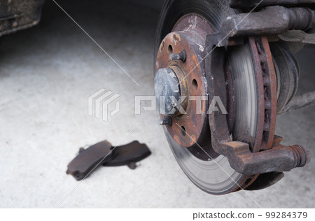 Car repair. Replacing the brake pads of disc brakes. Brake disc close-up. 99284379