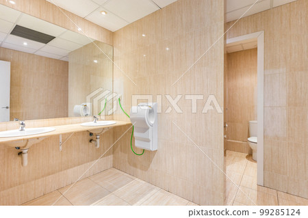Public toilet with big mirror, handwashers, dryer and wc doors. 99285124