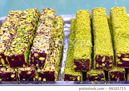 Oriental Sweets. Traditional Turkish Delight (Rahat Lokum) Close-up. Turkish Delight with nuts and shavings. Selective Focus Top View. 99285715