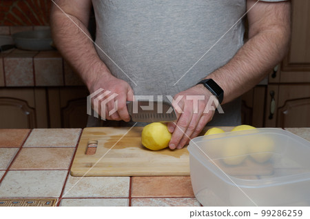 Cooking. Cutting raw potatoes on a cutting board 99286259