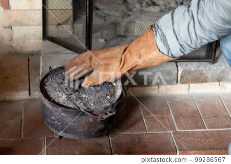 Cooking in an old dutch oven on the fireplace in a mountain hut 99286567