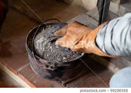 Cooking in an old dutch oven on the fireplace in a mountain hut 99286568