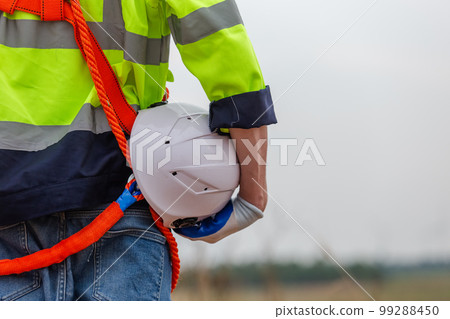 man engineer holding helmet safety wearing uniform standing at wind turbine 99288450