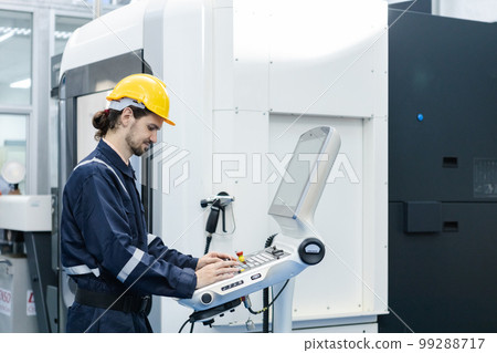 Man engineer using computer controlling cnc machine at workshop. professional male control 99288717