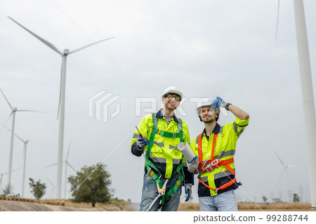 Team engineer wearing safety uniform discussed plan about renewable energy at station energy Team engineer wearing safety uniform discussed plan about renewable energy at station energy 99288744