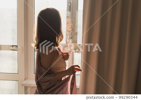 Young woman enjoying sunny morning on bedroom copy space and empty space for text - wake-up and wellness concept 99290344