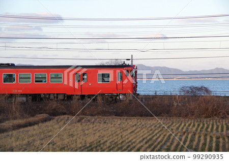 A vermilion local train running along the Nakaumi line in the evening 99290935