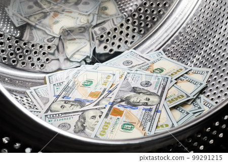 Close-up of washing dollars in machine, money laundering, financial fraud concept Close-up of washing dollars in machine, money laundering, financial fraud concept 99291215