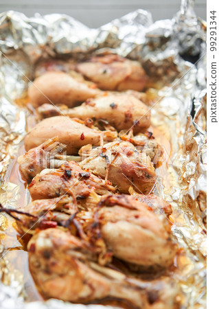 Baked chicken drumsticks without skin. Baked in foil with onions and seasonings. Home cooking. Healthy food, cooked without oil and salt. Baked chicken drumsticks without skin. Baked in foil with onions and seasonings. Home cooking. Healthy food, cooked without oil and salt. 99291344