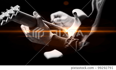 back of male musician playing electric guitar with orange flare. music background back of male musician playing electric guitar with orange flare. music background 99292791