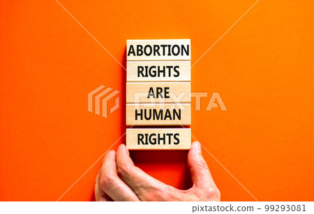 Abortion rights symbol. Concept words Abortion rights are human rights on wooden blocks. Businessman hand. Beautiful orange background. Business medical abortion rights concept. Copy space. 99293081