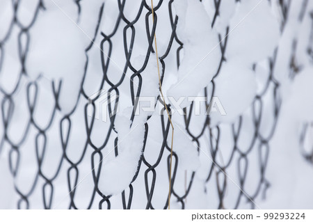 Snowy metal rabitz fence, abstract photo 99293224