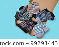 Striped socks of different colors, folded in half and laid out in a circle in a box, like a pizza, concept, close-up 99293443