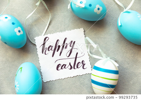 Happy Easter concept. Preparation for holiday. Blue Easter eggs Inscription HAPPY EASTER letters text on concrete stone grey background. Flat lay top view copy space Happy Easter concept. Preparation for holiday. Blue Easter eggs Inscription HAPPY EASTER letters text on concrete stone grey background. Flat lay top view copy space 99293735