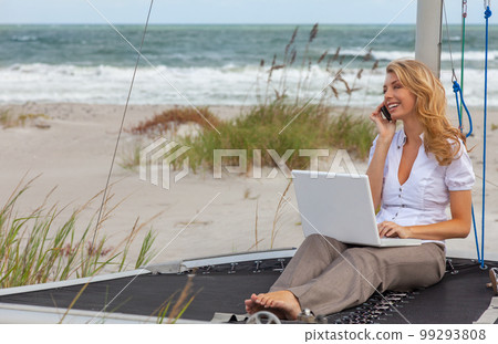 Young Woman Remote Working On Line Using Laptop On Boat At Beach 99293808