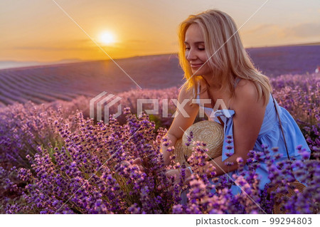 Woman lavender field sunset. Romantic woman walks through the la Woman lavender field sunset. Romantic woman walks through the la 99294803