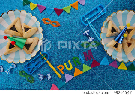 Purim celebration concept. Jewish carnival background. hamantaschen or hamans ears cookies, carnival mask and noisemaker Purim celebration concept. Jewish carnival background. hamantaschen or hamans ears cookies, carnival mask and noisemaker 99295547