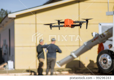As employees pour concrete near newly constructed home on construction site with help of drone an inspector controls pouring of concrete by employees 99296163