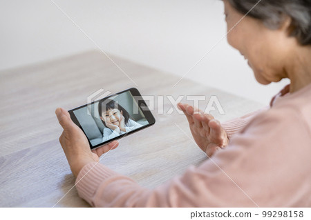 與孫子視頻通話的高級女性的手 與孫子視頻通話的高級女性的手 99298158