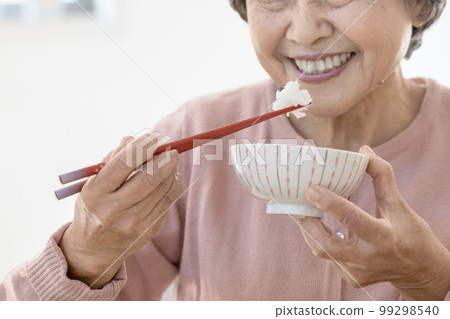 Senior woman's hand eating rice 99298540