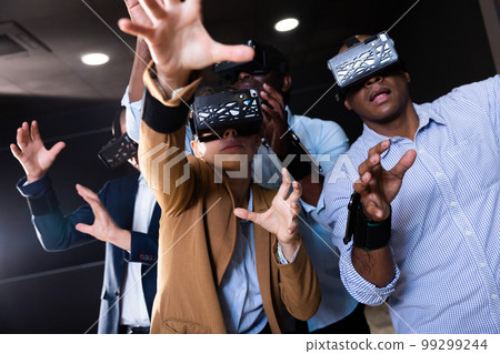 People using virtual reality glasses delighted with videogames People using virtual reality glasses delighted with videogames 99299244