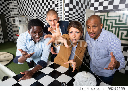 Quest game - group of adults reach for the key to complete the next level of game Quest game - group of adults reach for the key to complete the next level of game 99299369