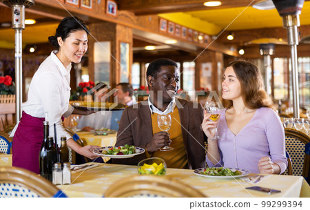 Asian waitress brought tray with restaurant guests 99299394