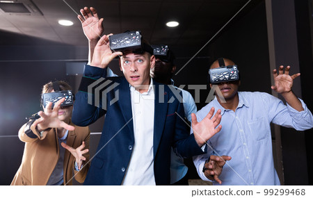 People using virtual reality headset and gesturing People using virtual reality headset and gesturing 99299468