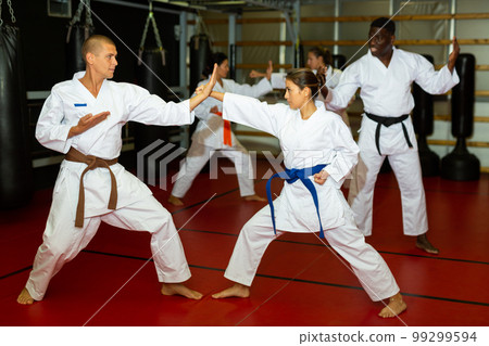 Man and women sparring during karate training Man and women sparring during karate training 99299594