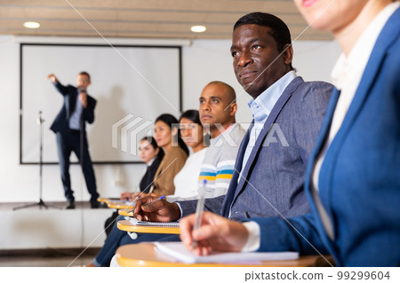 Focused man listening to lecture at conference Focused man listening to lecture at conference 99299604