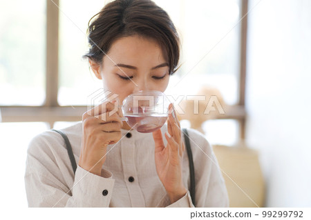 Photo of a woman drinking hot water Photo of a woman drinking hot water 99299792