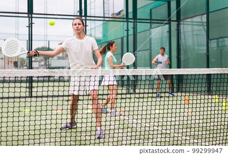 Portrait of focused woman during padel training 99299947