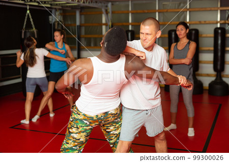 Men and women exercising during self-protection training 99300026