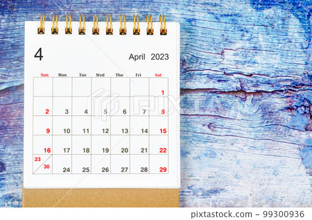 The April 2023 Monthly desk calendar for 2023 year on old blue wooden background. 99300936