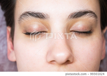 Woman lying on the couch after eyelash lamination procedure.  99301024