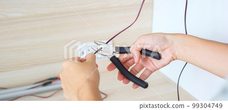Electrician cuts electrical wires with pliers, Wiring cables installation for socket plug. Fixing, Renovation, Repair, service and development of home and apartment concepts 99304749
