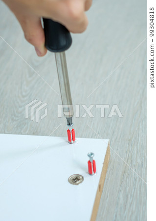 man using screwdriver assembling or repairing furniture at home. DIY, Renovation, repairing and development home or apartment concepts man using screwdriver assembling or repairing furniture at home. DIY, Renovation, repairing and development home or apartment concepts 99304818